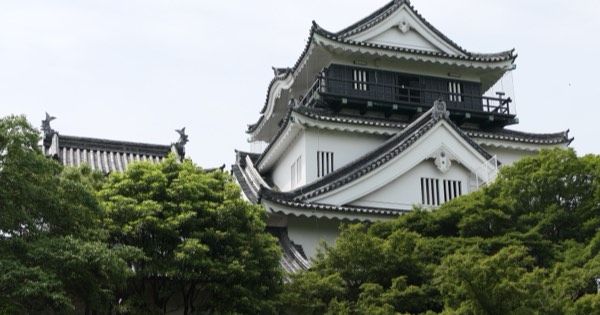 Okazaki Castle keep rising above green trees in Aichi Prefecture, Japan