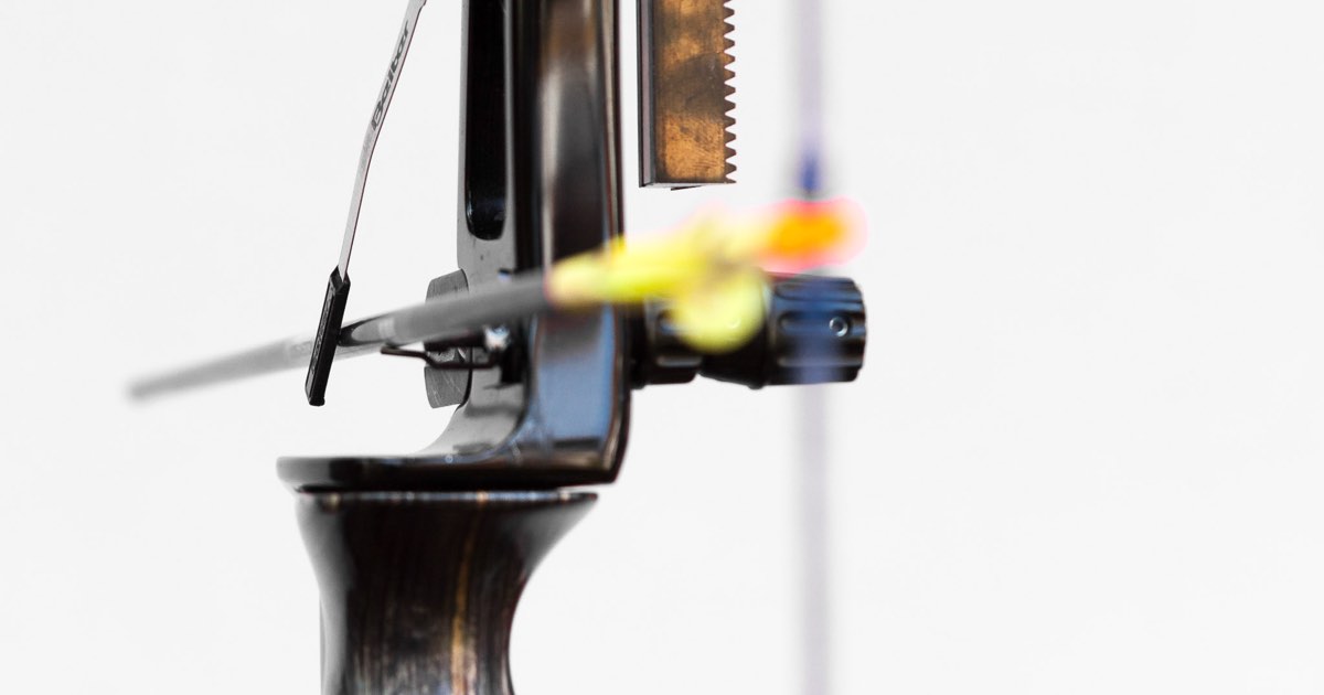 Close-up of a clicker on a target recurve riser with an arrow drawn underneath it