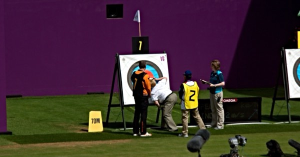 Judges and archers at the target checking line-cutter arrows at a competition