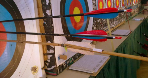 Arrows in front of World Archery indoor target faces at an indoor shooting hall